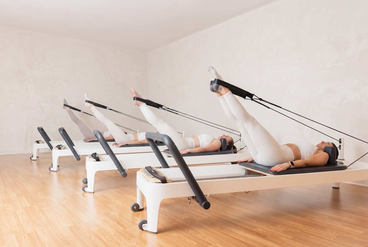 Pilates reformer teacher training class practicing on reformer machines