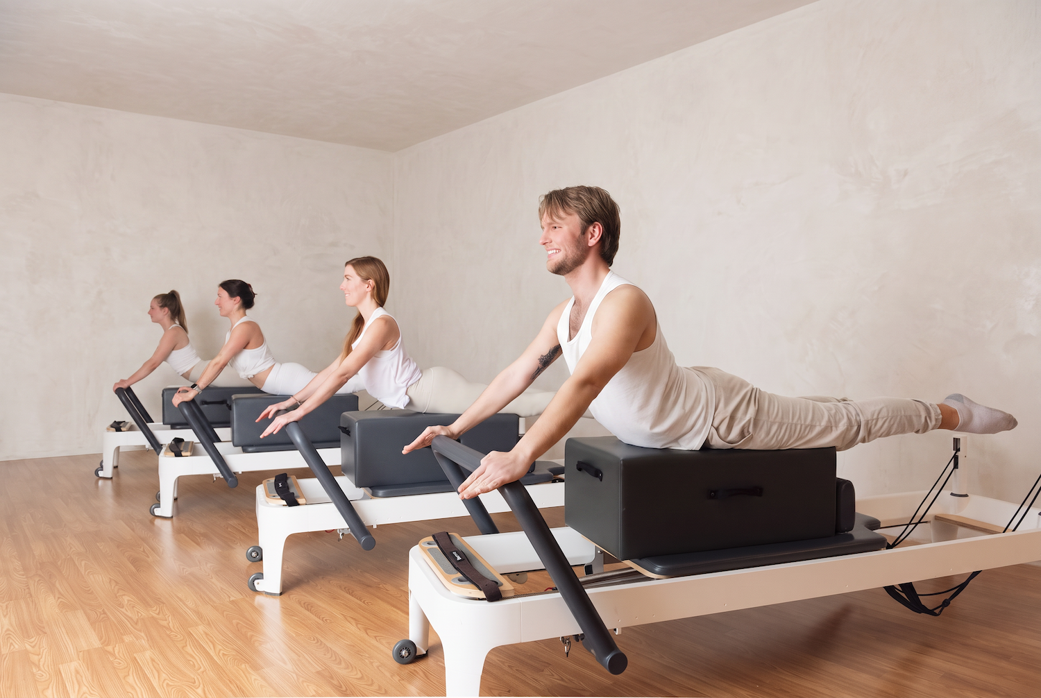 Pilates teacher training session four people on reformers